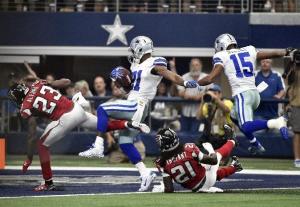 Atlanta Falcons cornerback Robert Alford (23) and cornerback Desmond Trufant (21) are sent flying along with Dallas Cowboys wide receiver Devin Street (15) as running back Joseph Randle (21) scores a touchdown on a running play during the first half of an NFL football game on Sunday, Sept. 27, 2015, in Arlington, Texas. (AP Photo/Michael Ainsworth )