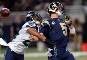 St. Louis Rams quarterback Nick Foles, right, fumbles as he is hit by Seattle Seahawks defensive back Cary Williams while throwing during the fourth quarter of an NFL football game Sunday, Sept. 13, 2015, in St. Louis. Williams recovered the fumble and returned the ball for a touchdown. (AP Photo/Tom Gannam)